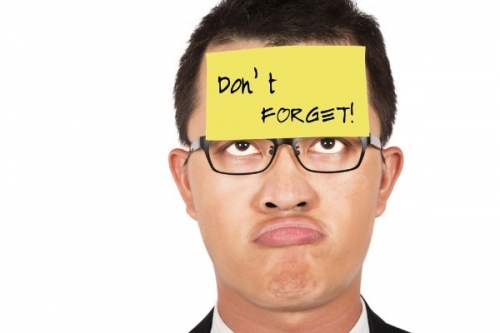 man in glasses with sign on forehead that reads don't forget!